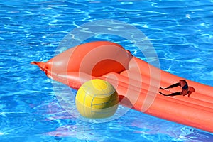 Inflatable mattress and volleyball in pool