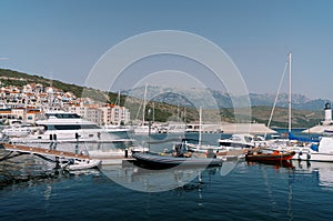 Inflatable motor boats stand next to yachts at the marina berths photo