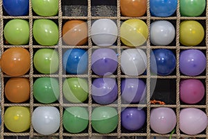 Inflatable multi-colored balls in the cells for playing darts, close up