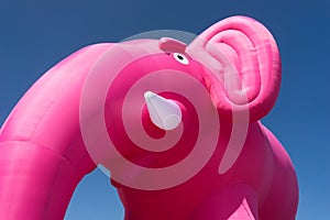 Inflatable pink elephant on a background of blue sky