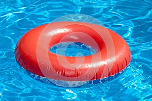 Inflatable red swim ring on blue pool