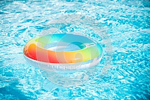 Inflatable ring in blue swimming pool. Colorful inflatable toy in swimming pool water, summer vacation background.