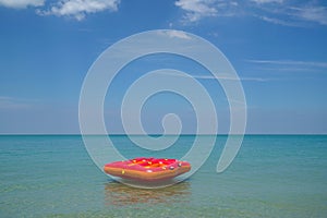 Inflatable ring or lilo in the sea by the beach