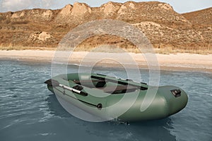 Inflatable rubber fishing boat floating in sea near coast