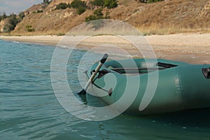 Inflatable rubber fishing boat floating in sea near coast