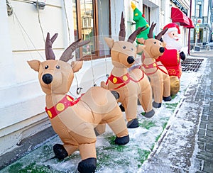 Inflatable Santa Claus and reindeer on the street. Christmas design. New Year\'s decoration on the street.