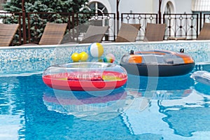 Inflatable water activities, balls, mattresses, circles, tubes float on the water in the pool