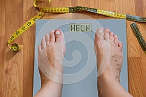 Inflated feet of woman on weighting scale asking for help to lose weight. Diet concept