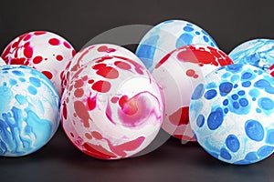 Inflated white balloon with red and blue spots isolated on a black background.