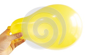 Inflated yellow balloon in hand isolated on white