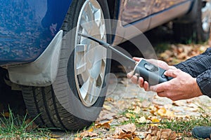 Inflating car tires with a portable wireless air pump outdoor