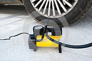 Inflating a flat tire, wheel with an electric pump on a road, maintenance and car service