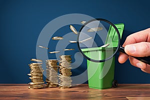 Inflation concept with coins and garbage can