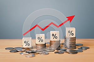 Inflation concept, red graph arrow, Percent sign on a wooden cube with row of coins in idea for interest rate hike, world