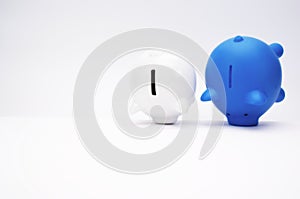 Inflation and devaluation concepts - Blue White Piggy Bank against white wall background
