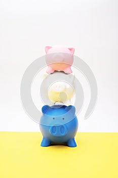 Inflation and devaluation concepts - Stack of Piggy Bank diminishing in size on a yellow surface against white wall