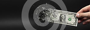 Inflation, dollar hyperinflation. Banner with black background. One dollar bill is sprayed in the hand of a man on a