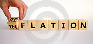 Inflation or reflation symbol. Businessman turns cubes and changes the word inflation to reflation. Beautiful white background,