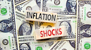 Inflation shocks symbol. Concept words Inflation shocks on wooden blocks. Beautiful background from dollar bills. Business