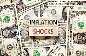 Inflation shocks symbol. Concept words Inflation shocks on wooden blocks. Beautiful background from dollar bills. Dollar bills.