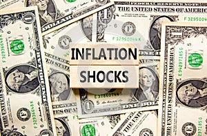 Inflation shocks symbol. Concept words Inflation shocks on wooden blocks. Beautiful background from dollar bills. Dollar bills.