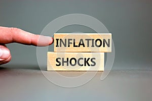 Inflation shocks symbol. Concept words Inflation shocks on wooden blocks. Beautiful grey table grey background. Businessman hand.