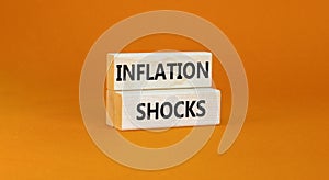 Inflation shocks symbol. Concept words Inflation shocks on wooden blocks. Beautiful orange table orange background. Business