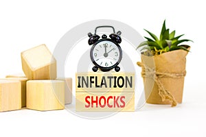 Inflation shocks symbol. Concept words Inflation shocks on wooden blocks. Beautiful white table white background. Black alarm
