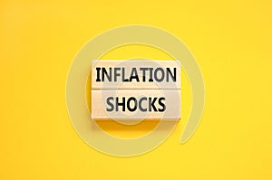 Inflation shocks symbol. Concept words Inflation shocks on wooden blocks. Beautiful yellow table yellow background. Business