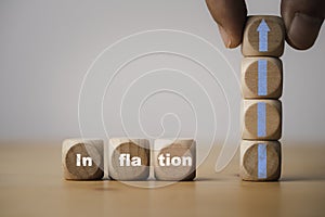 Inflation wording print screen on wooden cube block with hand holding up arrow for economic business growth and recession concept