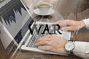 Influence of war on stock exchange. Man using laptop at table and illustration of rating graph