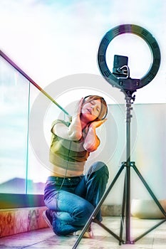 Influencer girl streaming live video with smartphone and ring light