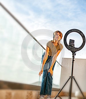 Influencer girl streaming live video with smartphone and ring light