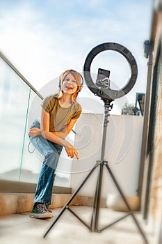 Influencer girl streaming live video with smartphone and ring light