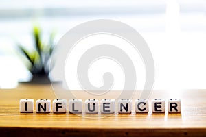 Influencer message text on white blocks on a wooden table