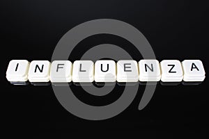 Influenza text word title caption label cover backdrop background. Alphabet letter toy blocks on black reflective background. Whit