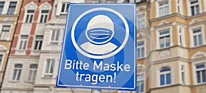 Info sign with German text  `Bitte tragen Sie eine Maske!` `Please wear a mask!`