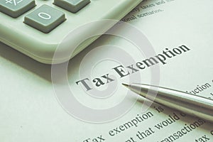 Info about tax exemption with calculator and pen. photo