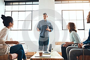 Informal meetings work best for their business. a group of young businesspeople having a meeting in a modern office.