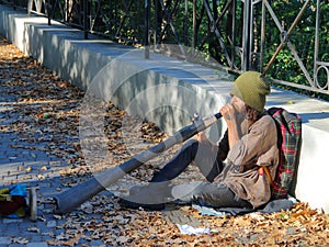 Informal street musician playing on Didgeridoo.