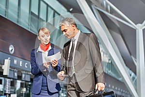 Information service agent assisting passenger to his gate in airport