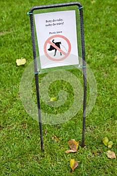 An information sign in a park intended for a picnic in Prague, Czech Republic, with the words ` Boots in the hand, feet in the gra