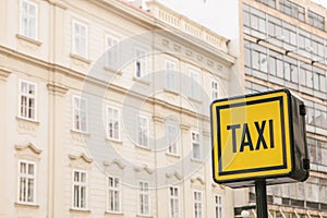 Information sign of a taxi on the background of houses in a European city.