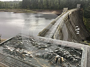 An information tile and Laggan Dam structure at Loch Laggan and River Spean in Scotland