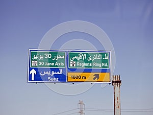 An informative side traffic signboard on Suez Cairo desert highway shows directions to the exit of the regional ring road, June