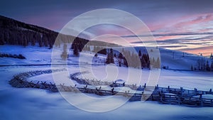 Infrared snowy landscape with snow barriers after sunset with animal footprints