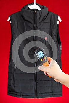 infrared thermometer shows the Fahrenheit temperature of electric heating vest