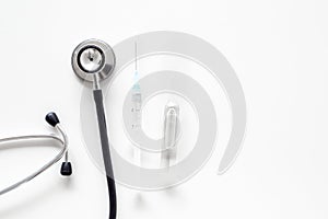 Infuenza vaccine in syringe near stethoscope on white background top view copy space