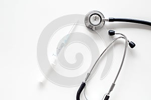 Infuenza vaccine in syringe near stethoscope on white background top view copy space