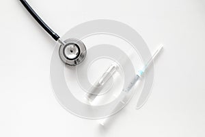 Infuenza vaccine in syringe near stethoscope on white background top view copy space